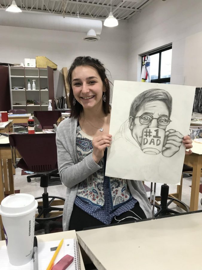 Emily Gard holding up a drawling of her father, Steve Gard.
