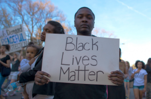 A man holds up a “Black Lives Matter” sign at a protest. 