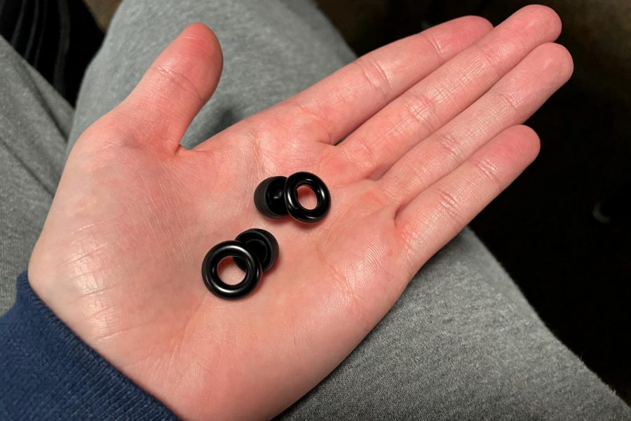 Chris Aukes (author) holding black Loop Experience Pro’s in a school environment. These earplugs aid in volume control in schools, workplaces, and other noisy places.