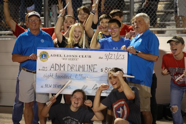 The Drumline celebrates as they are handed a check from the Lions Club, funding new equipment. 
