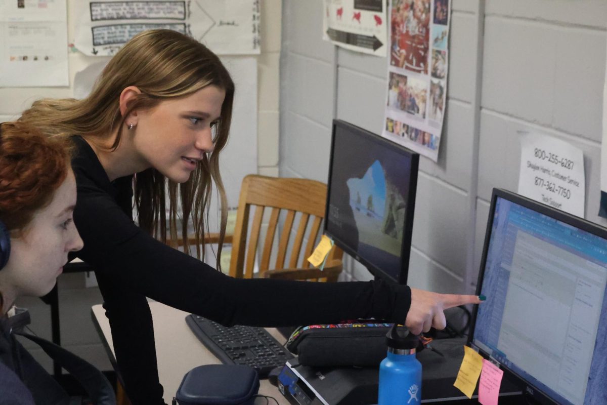 Delaney Kahler works on a story with student journalist, Kaylin Dains, to meet a deadline.
