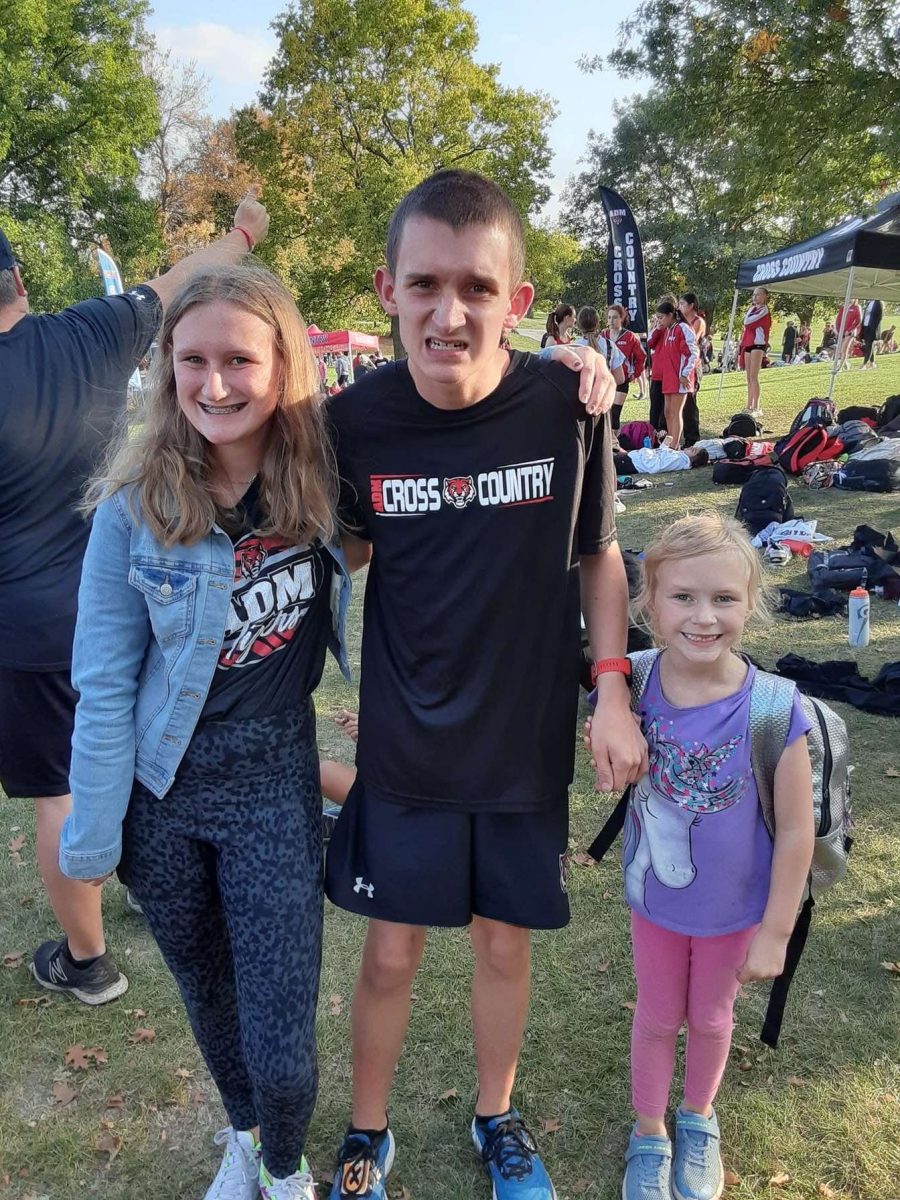 Aubree Timmer. Brycen Timmer, and their little sister Callie Timmer take a group picture after Brycen ran at his Cross Country meet