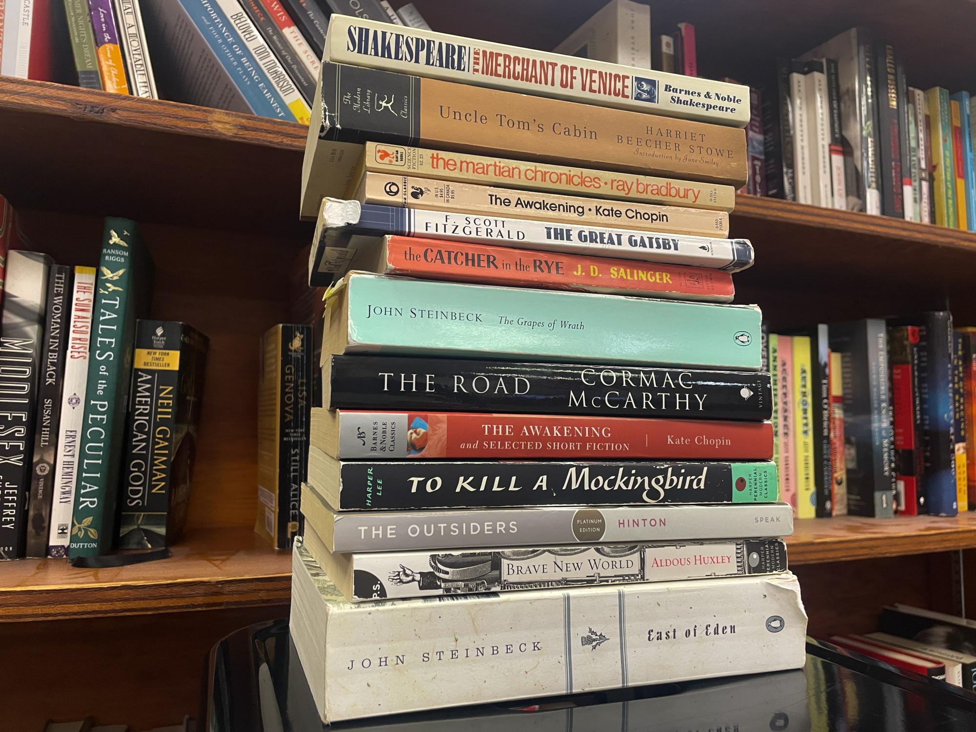 A stack of well-known classic novels in no particular order, featuring some novels such as, The Outsiders by SE Hinton and Uncle Tom's Cabin by Harriet Beecher Stowe. 