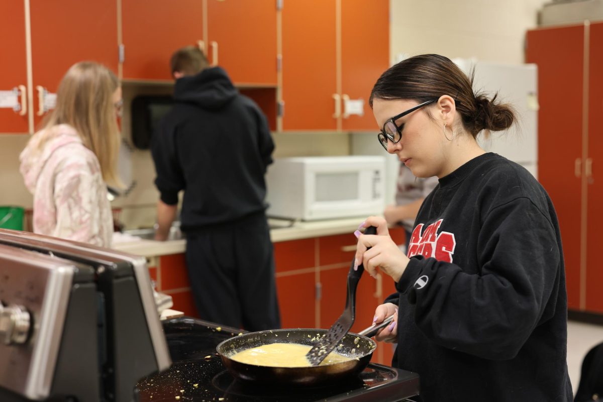 Jayda Petithory scrambles eggs for FFA's teacher breakfeast, hosted in the culinary room before school on Thursday.