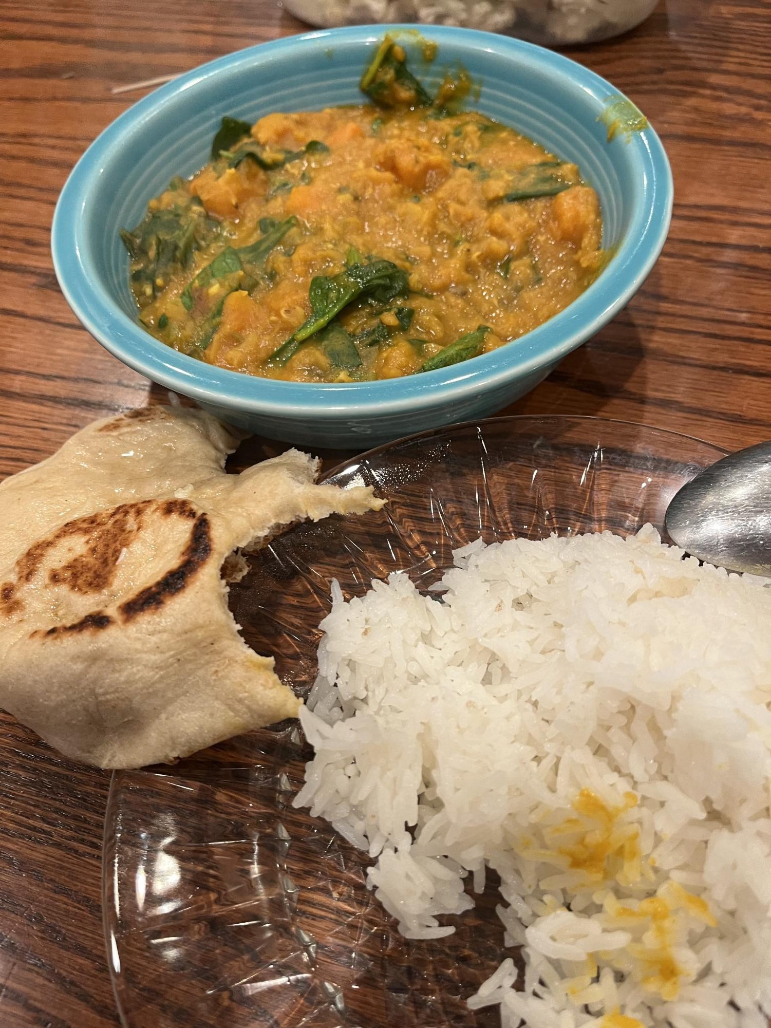 Homemade lentil curry, naan bread, and rice plated up for a family dinner.